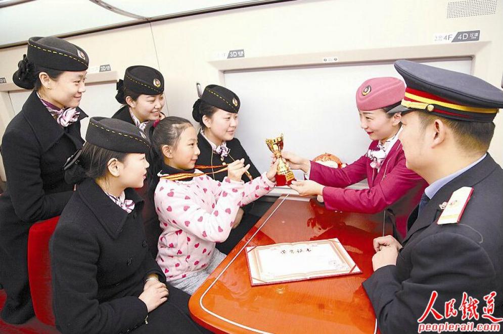 　　1月27日，郑州客运段K869/870次列车长贾慧斌和女儿贾乐佳一起到郑州东站给出乘的妻子李鹏送上奖状。 张 强 摄
