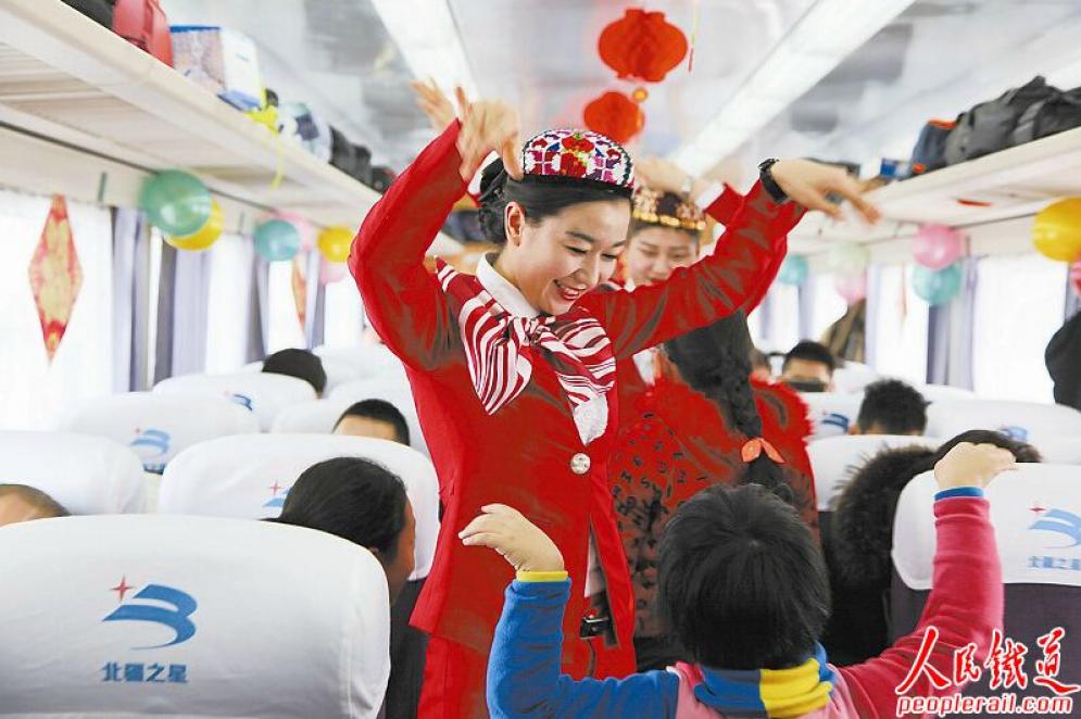 　　日前，乌鲁木齐客运段 “南疆之星”列车乘务员带着小旅客在车厢内一起欢乐地舞蹈。 庞玉玲 摄　　

