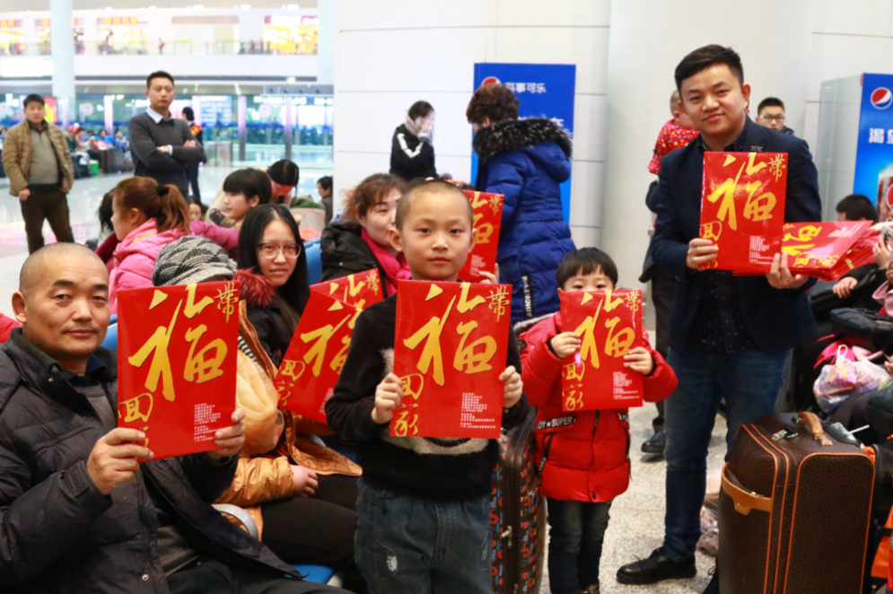 1月13日，在乌鲁木齐新客站，邀请的疆内知名书法家们挥毫泼墨，为旅客写春联，送祝福。